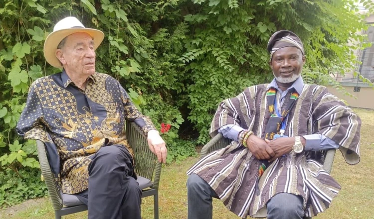 Albie Sachs sitting Emmanuel Frimpong in the garden