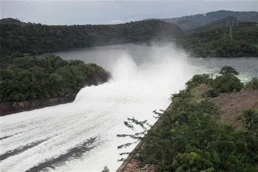 Destinations - Water gushing powerfully through the Akosombo Dam, with surrounding greenery.